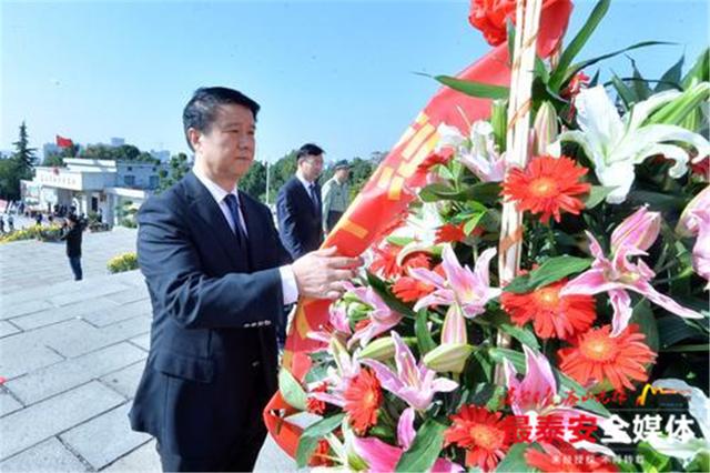 崔洪刚,张涛,唐福泉,隋阳,李保泉沿台阶登上纪念碑基座,仔细整理花篮